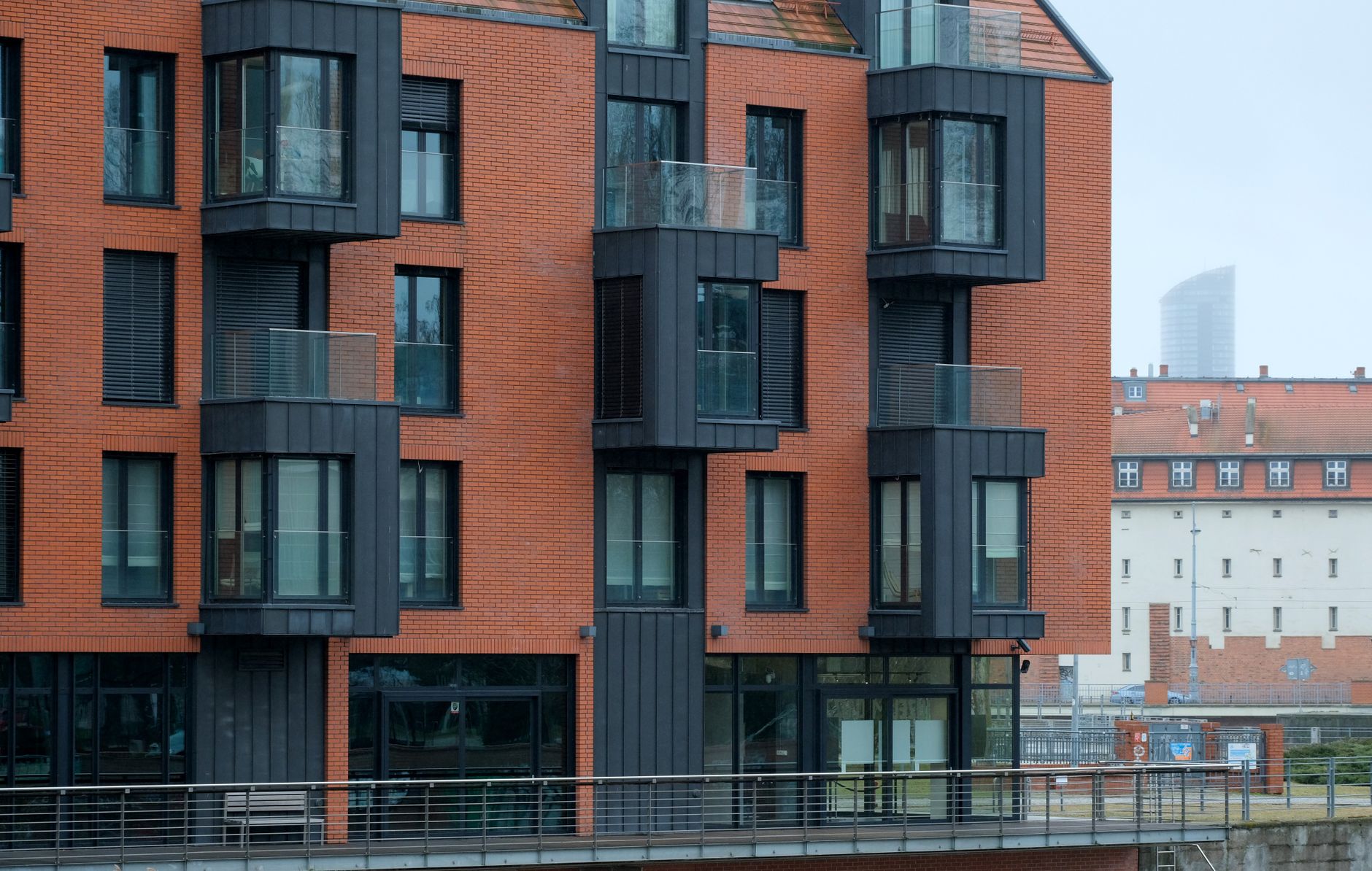Contemporary red brick building with bold architecture and glass balconies.