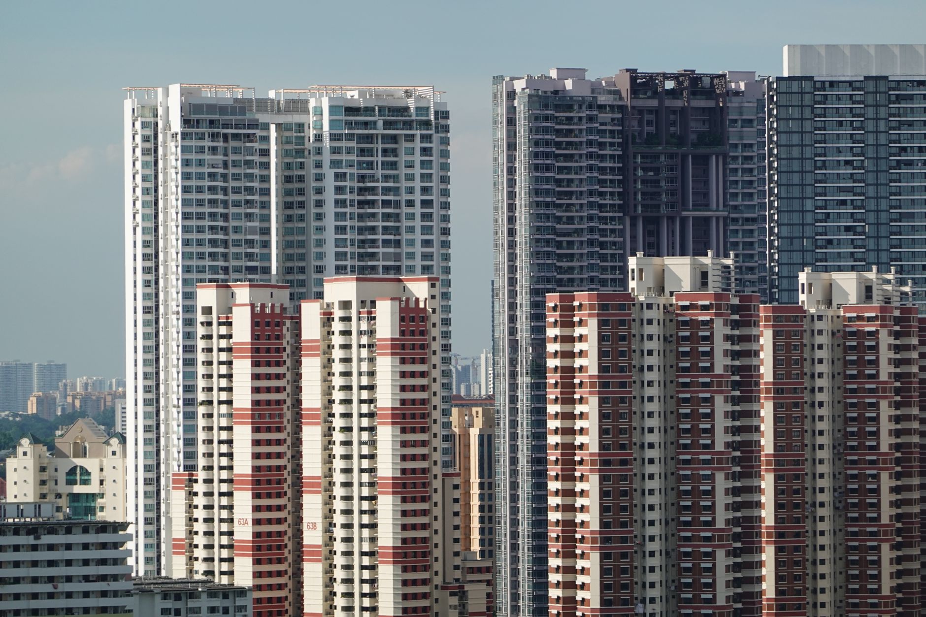 A cityscape featuring tall residential high-rise buildings under a clear sky.