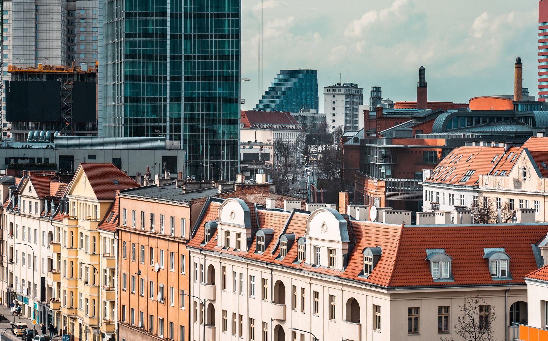 A vibrant cityscape of Poznań showcasing modern skyscrapers and historic architecture.