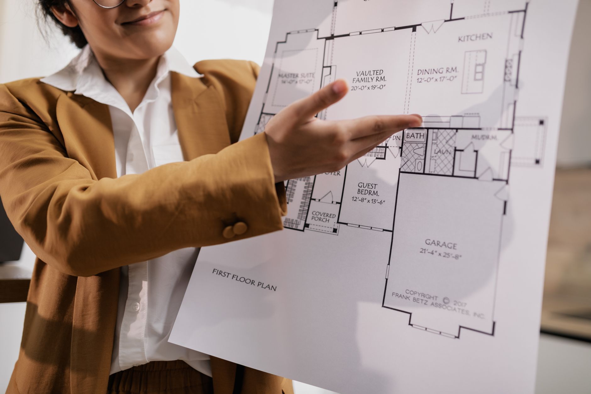 A real estate agent showcases a detailed home floor plan for potential buyers.