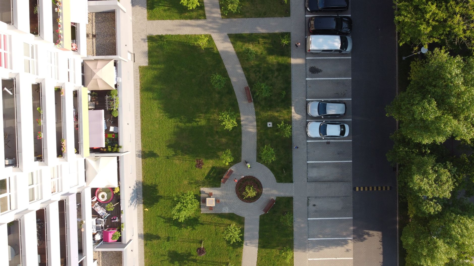 Aerial photo of a residential complex with green areas and parking in Łódź, Poland.
