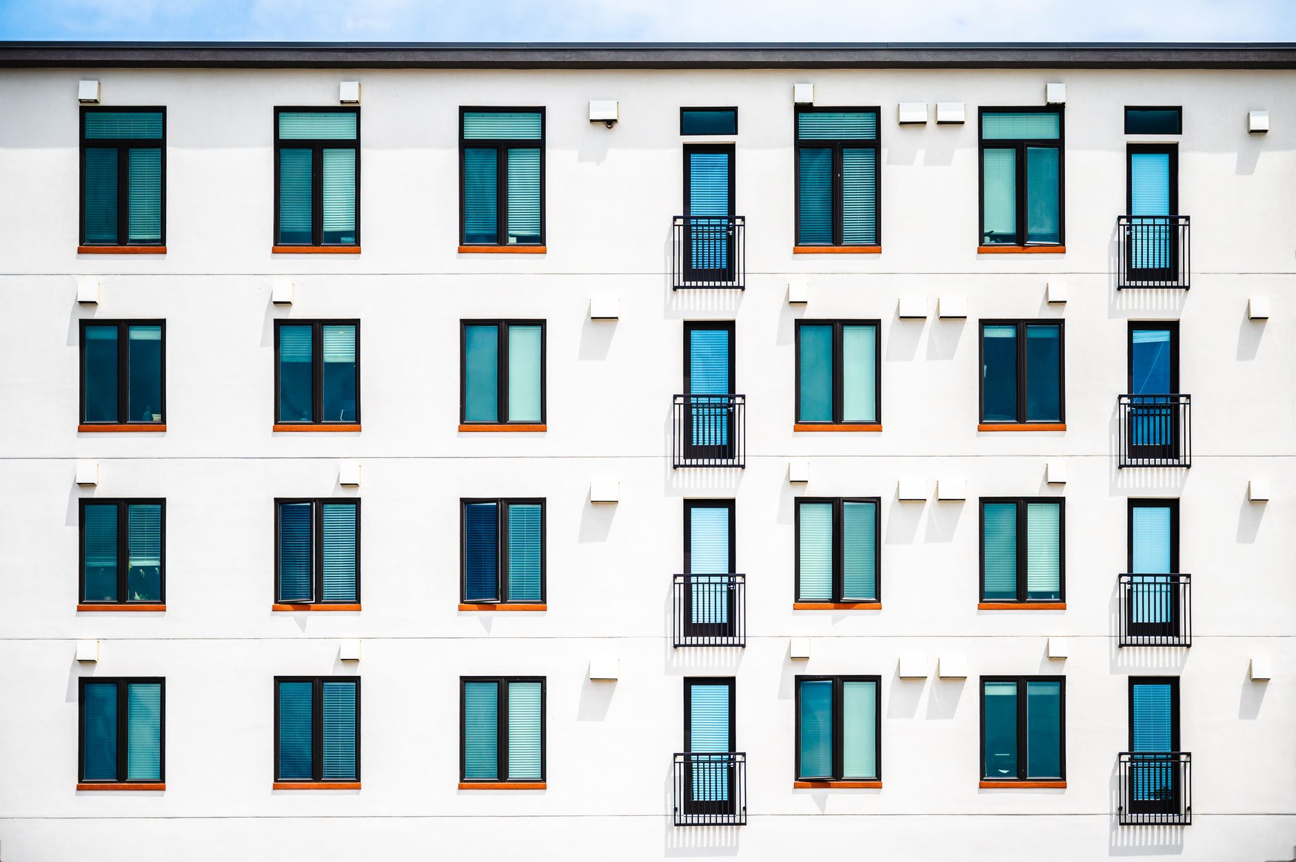 Facade of new white apartment building of simple minimalist style on clear day