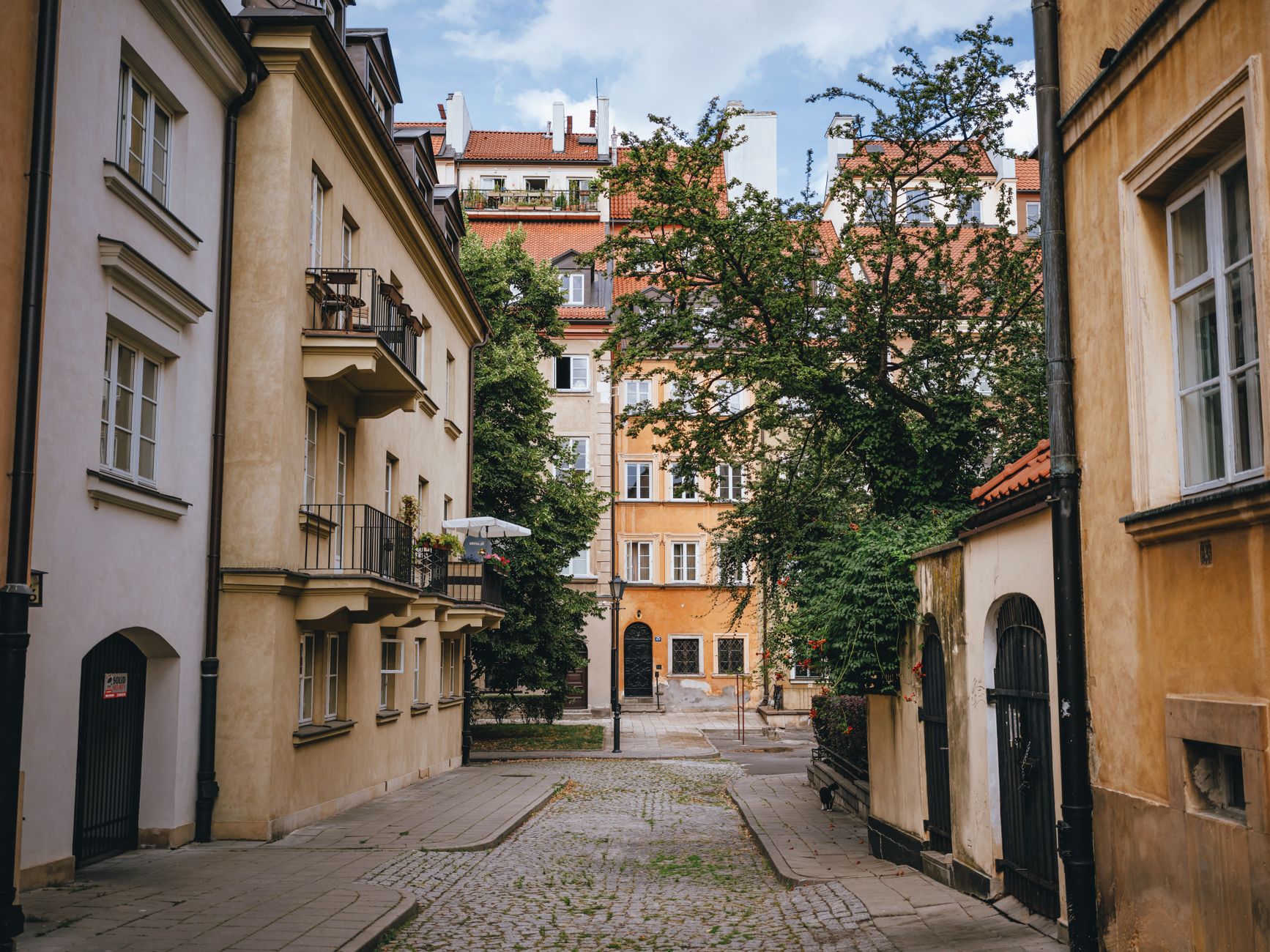 Picturesque European alley lined with charming historic buildings and cobblestone pavement.