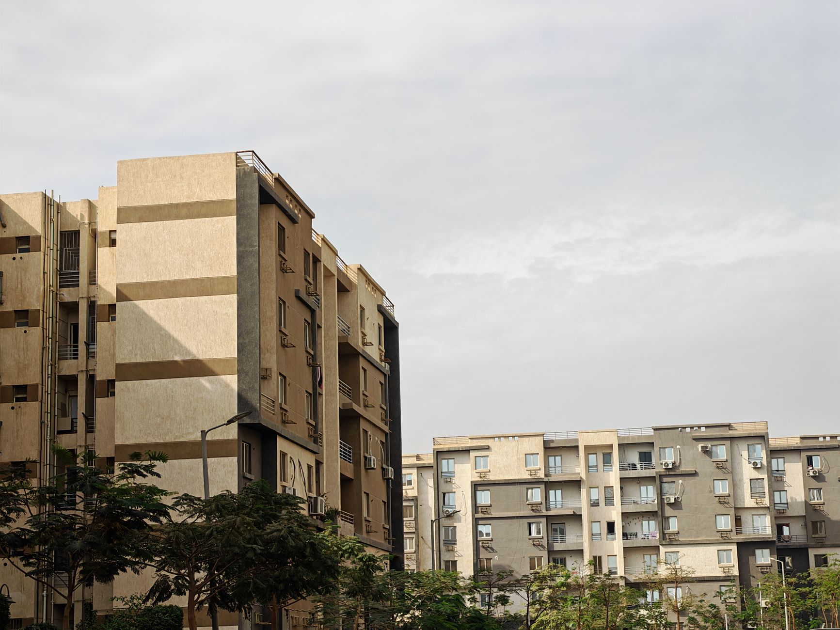 Capture of modern apartment buildings with a cloudy sky background, showcasing urban architecture.