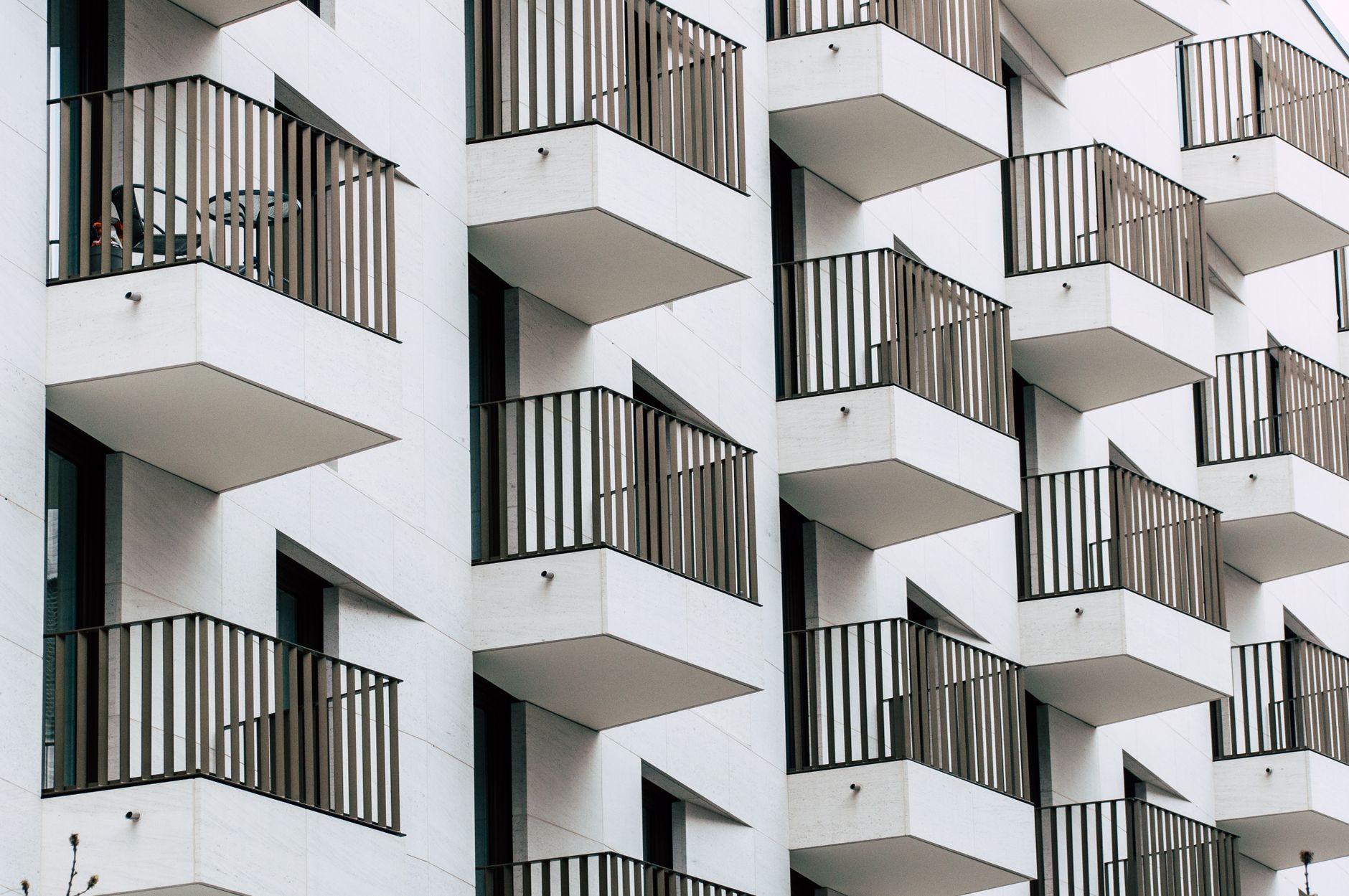 Urban apartment building with geometric balconies in modern architectural style.