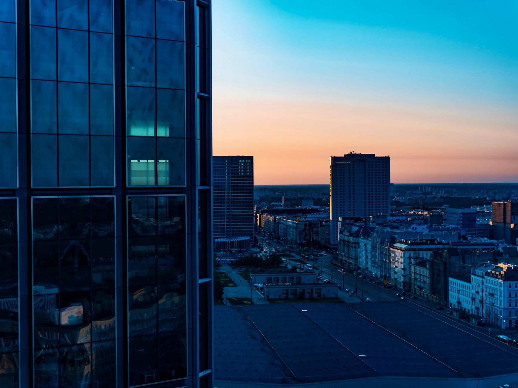 Modern skyscrapers in downtown Warsaw during a beautiful sunset, showcasing urban architecture.