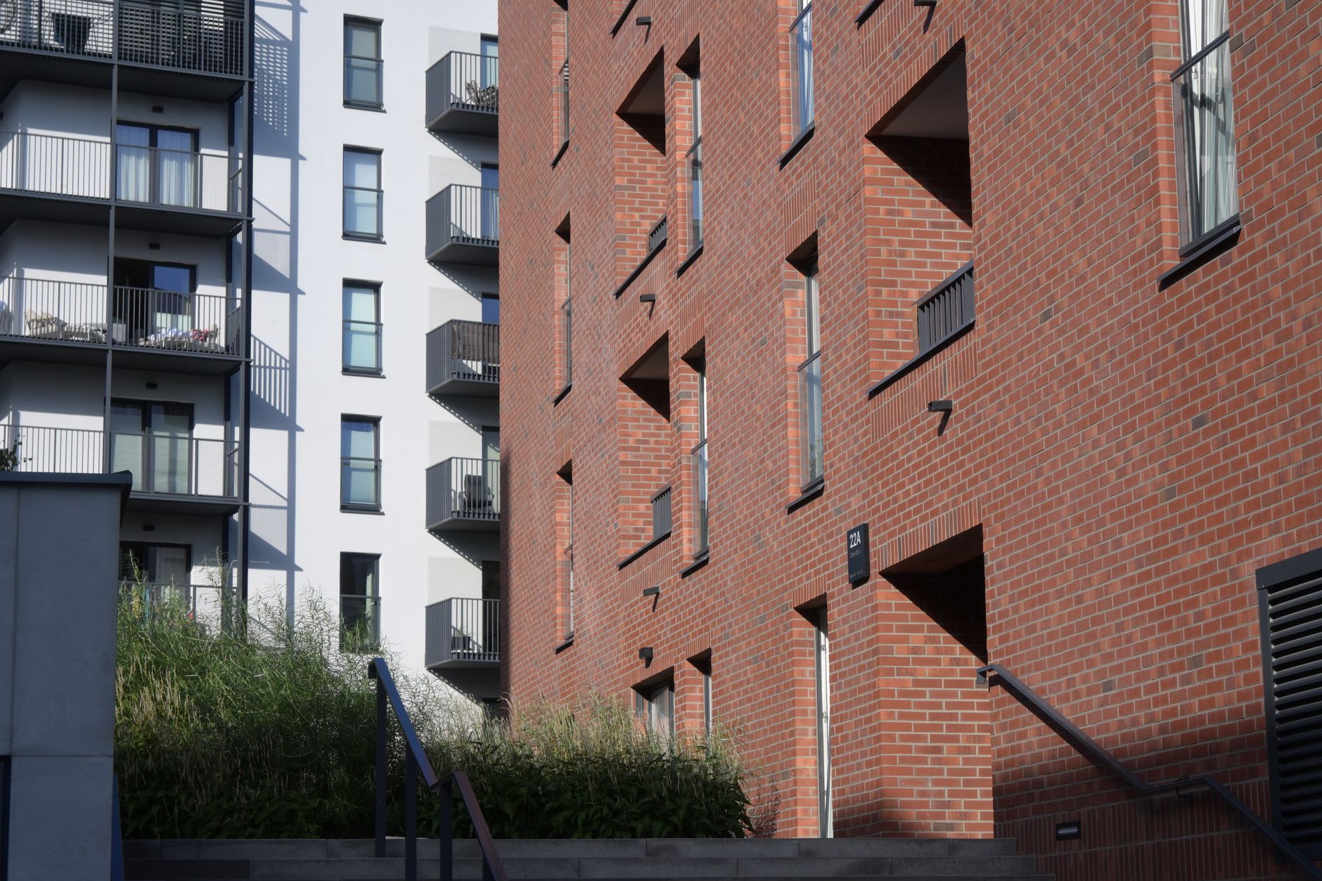 Urban view of modern residential buildings in Warsaw, featuring brick and concrete facades.