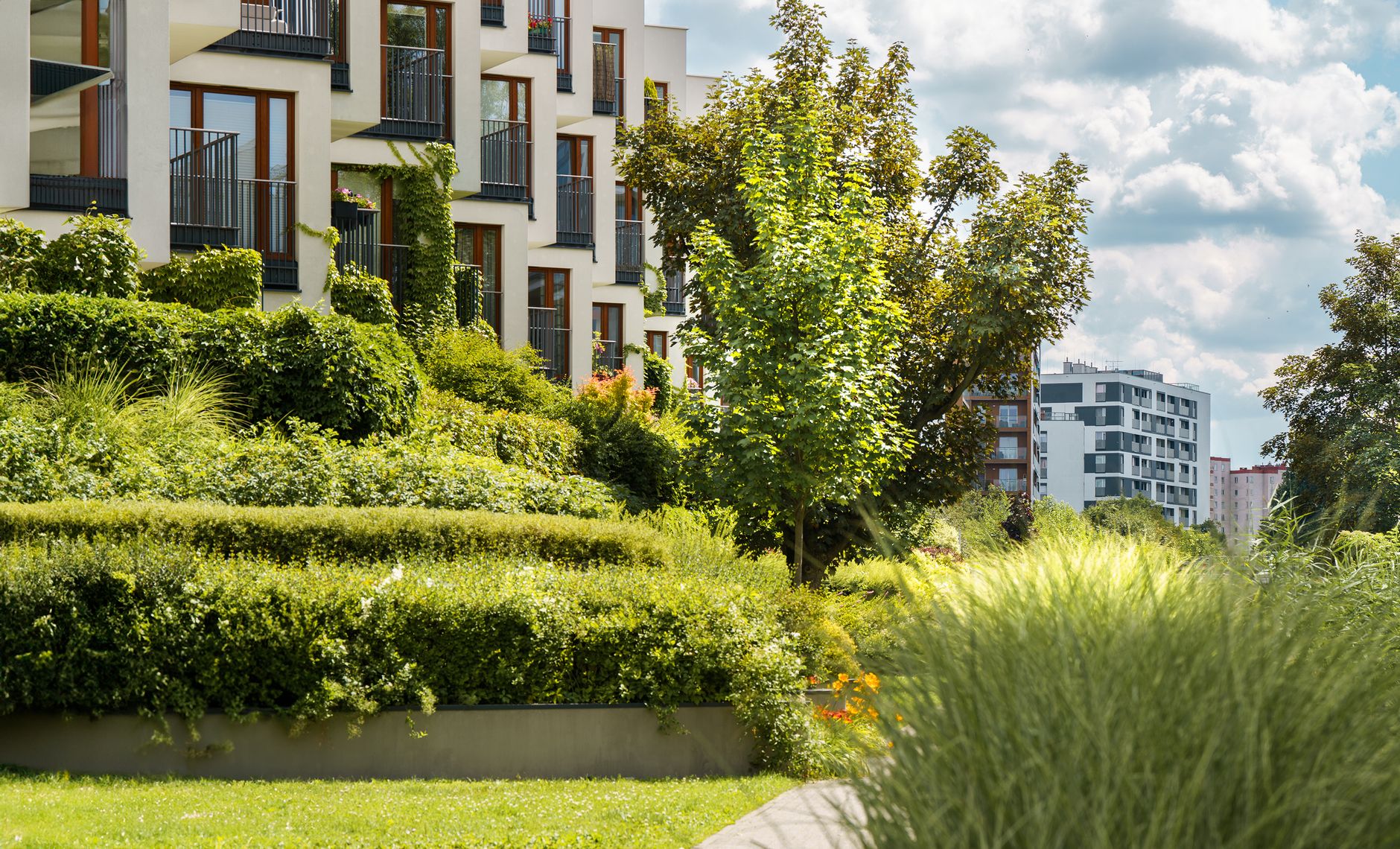 Elegant modern residential complex with lush gardens and urban landscape views.