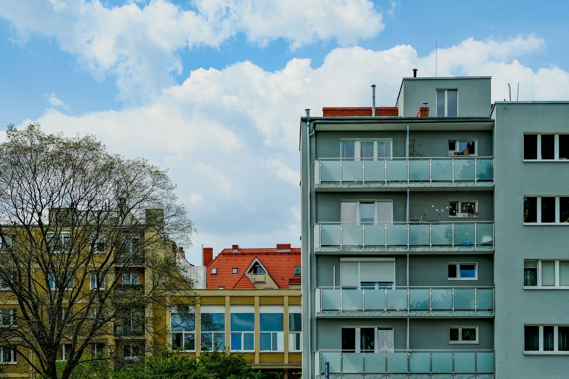 City apartment buildings with diverse architectural styles under a clear blue sky.