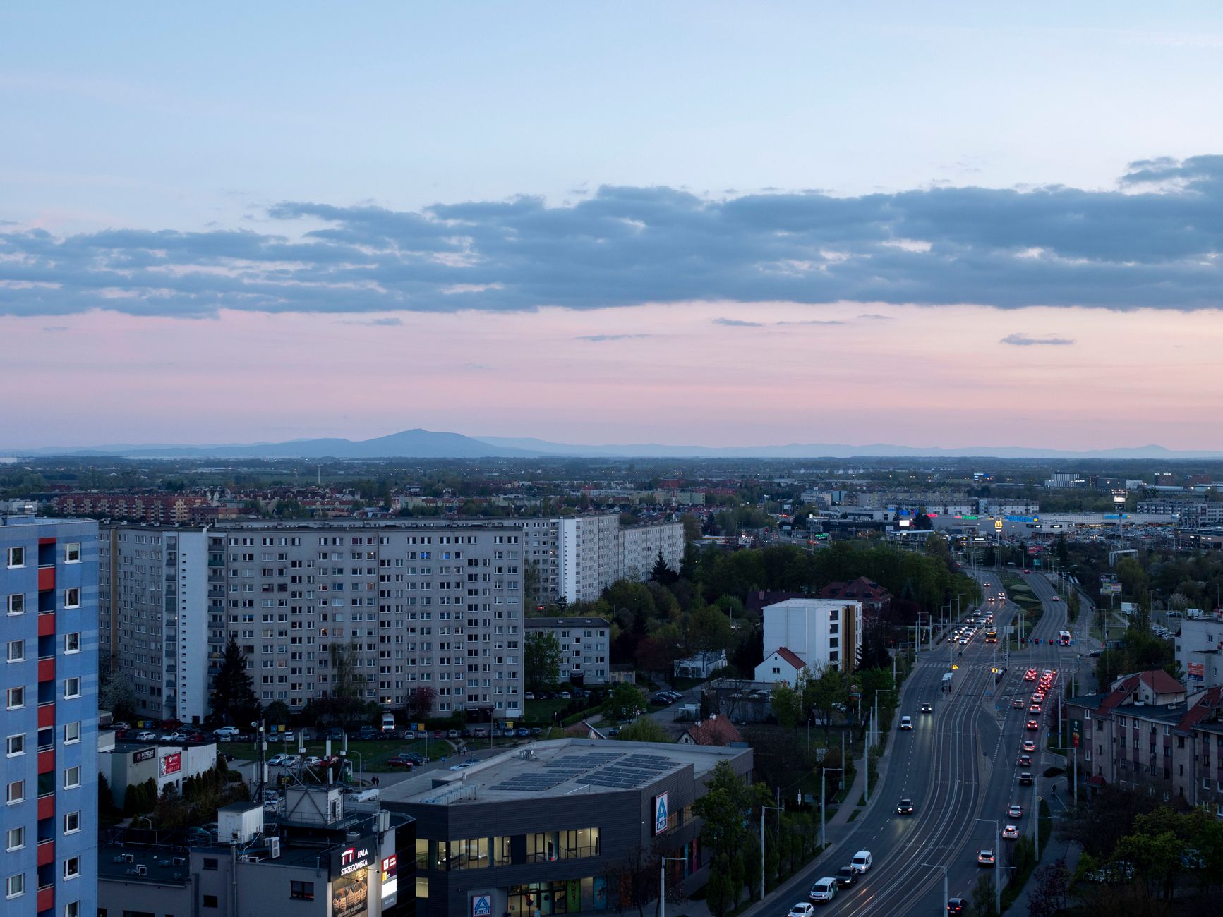 An expansive view of Wrocław's cityscape at sunset capturing residential and commercial buildings under a vivid sky.