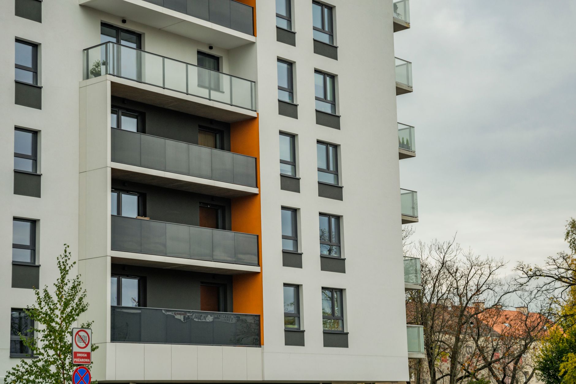 Contemporary apartment building facade with balconies on a cloudy day.