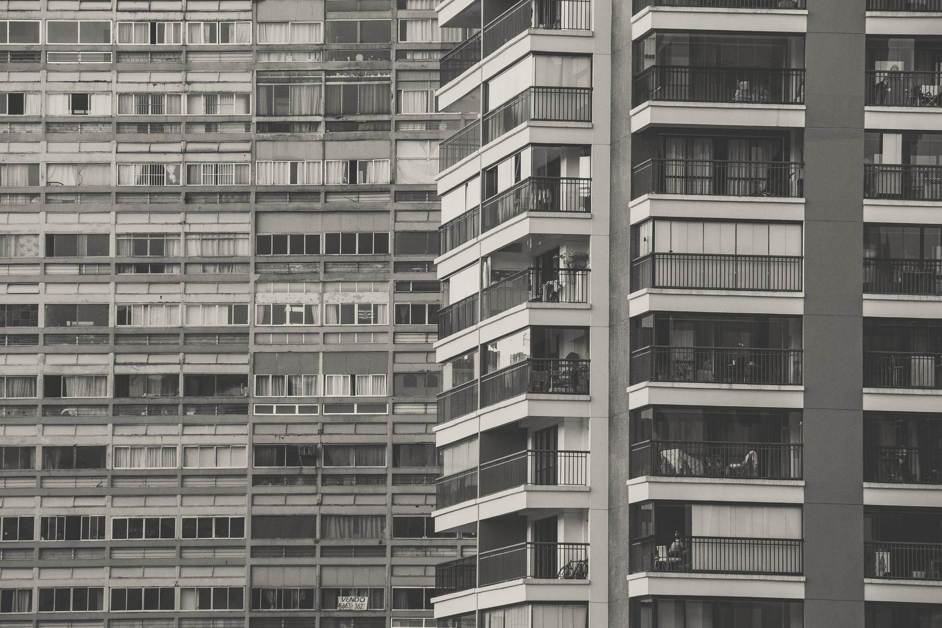 A low angle view of modern high-rise apartment buildings with balconies, creating a dense urban landscape.