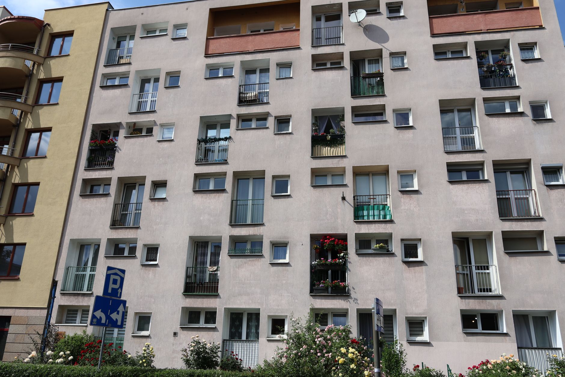 Facade of a modern apartment building in Wrocław with balconies and flowers.