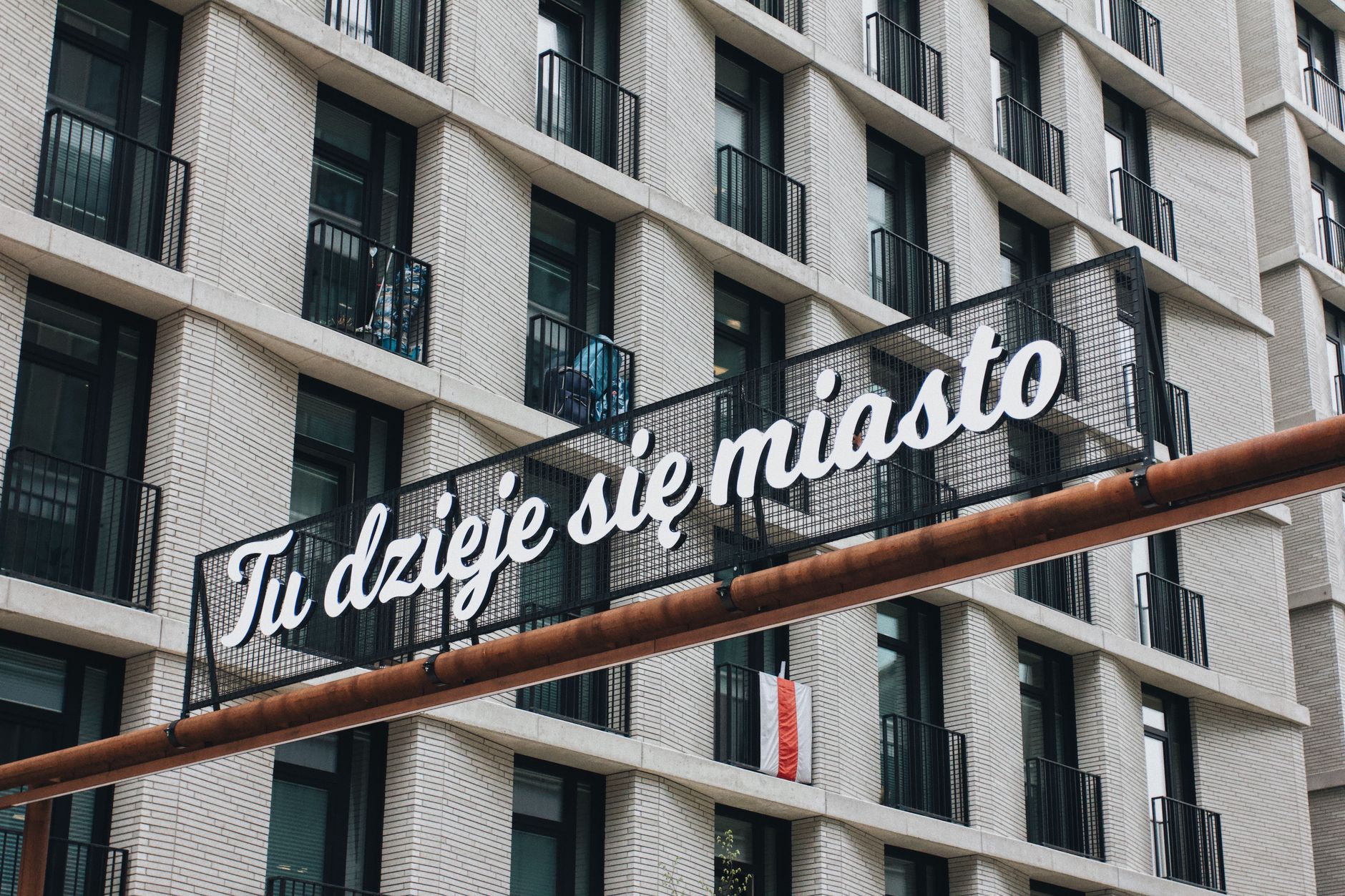 Modern building facade with a Polish sign in Warsaw, Poland.