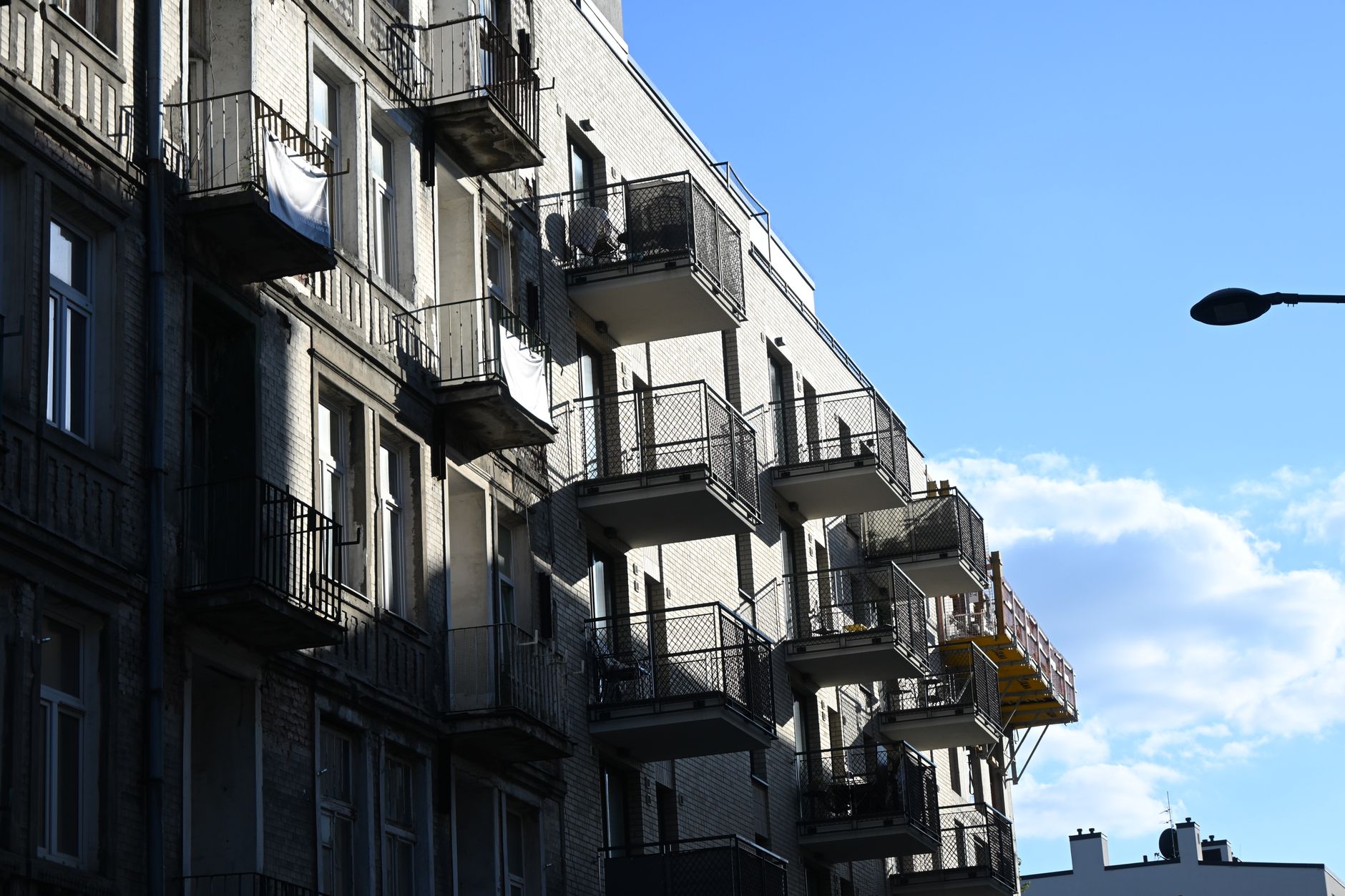 Facade of a historic apartment building in Warsaw, Poland on a sunny day.