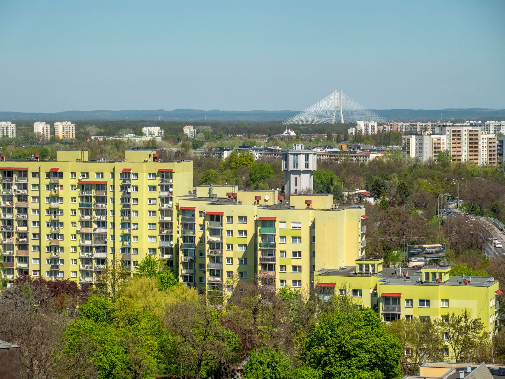 Urban landscape of Wrocław with residential buildings and iconic Rędziński Bridge.