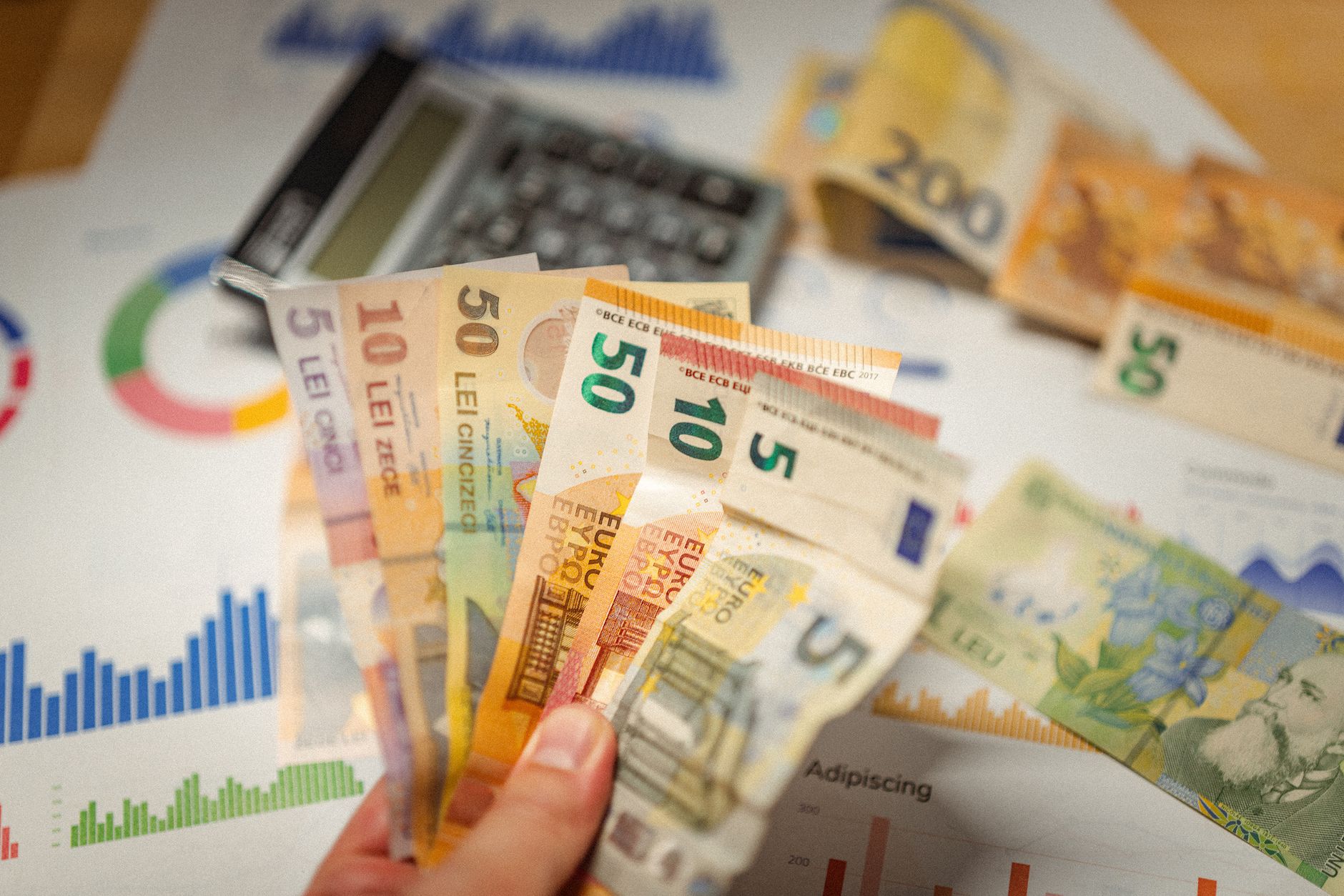 Close-up of currency notes with financial graphs and a calculator.