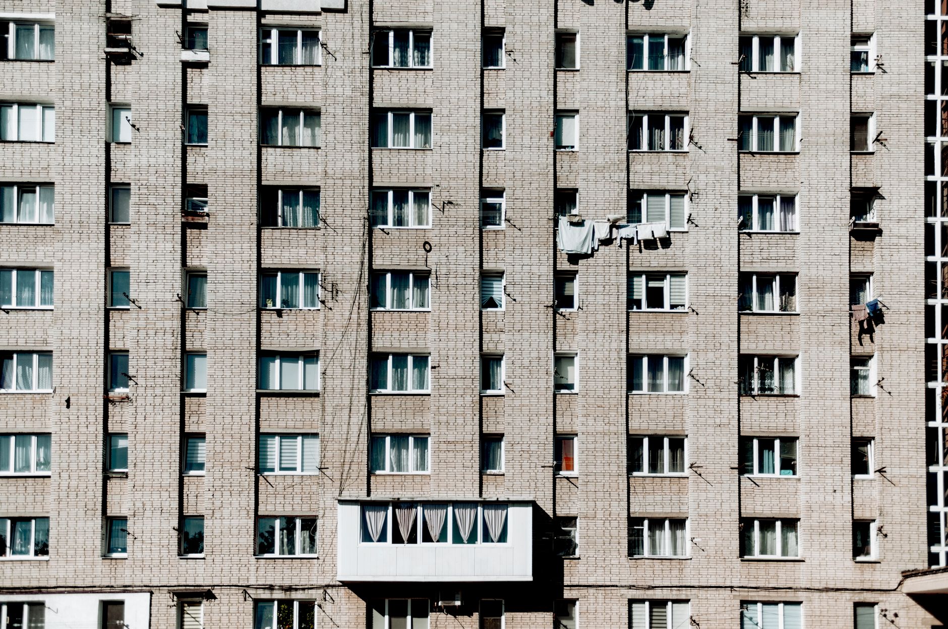 Front view of a Soviet-style apartment building in Lviv, featuring uniform windows and brick facade.