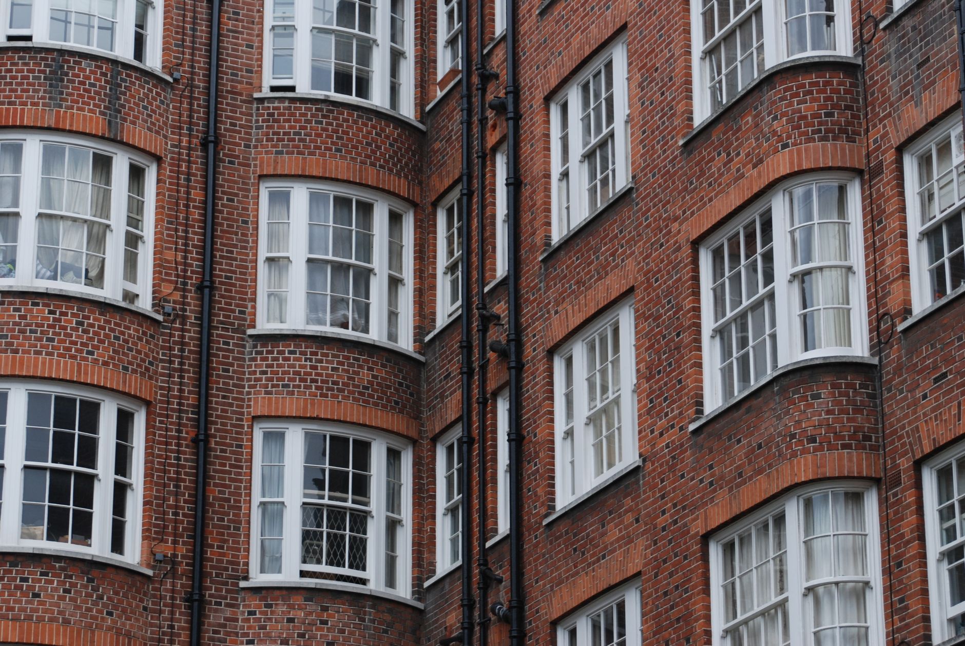 Red brick residential building with traditional windows in London, highlighting classic urban architecture.